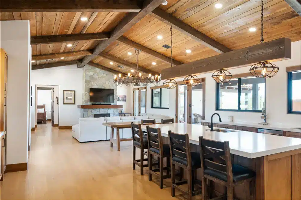 Modern barndominium open concept with wood plank ceiling and stone fireplace